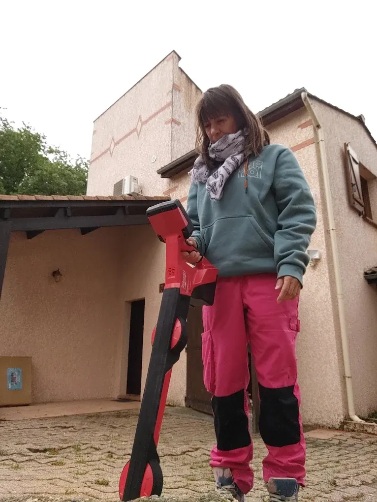 La technicienne Aqua’Détect’Occitanie avec son appareil de détection à proximité d’une maison